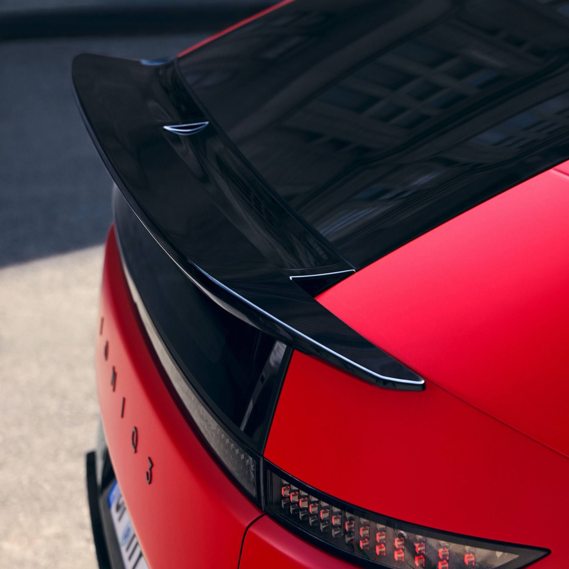 Red Hyundai IONIQ 3 rear detail with black roof spoiler and pixel-style LED taillight design.