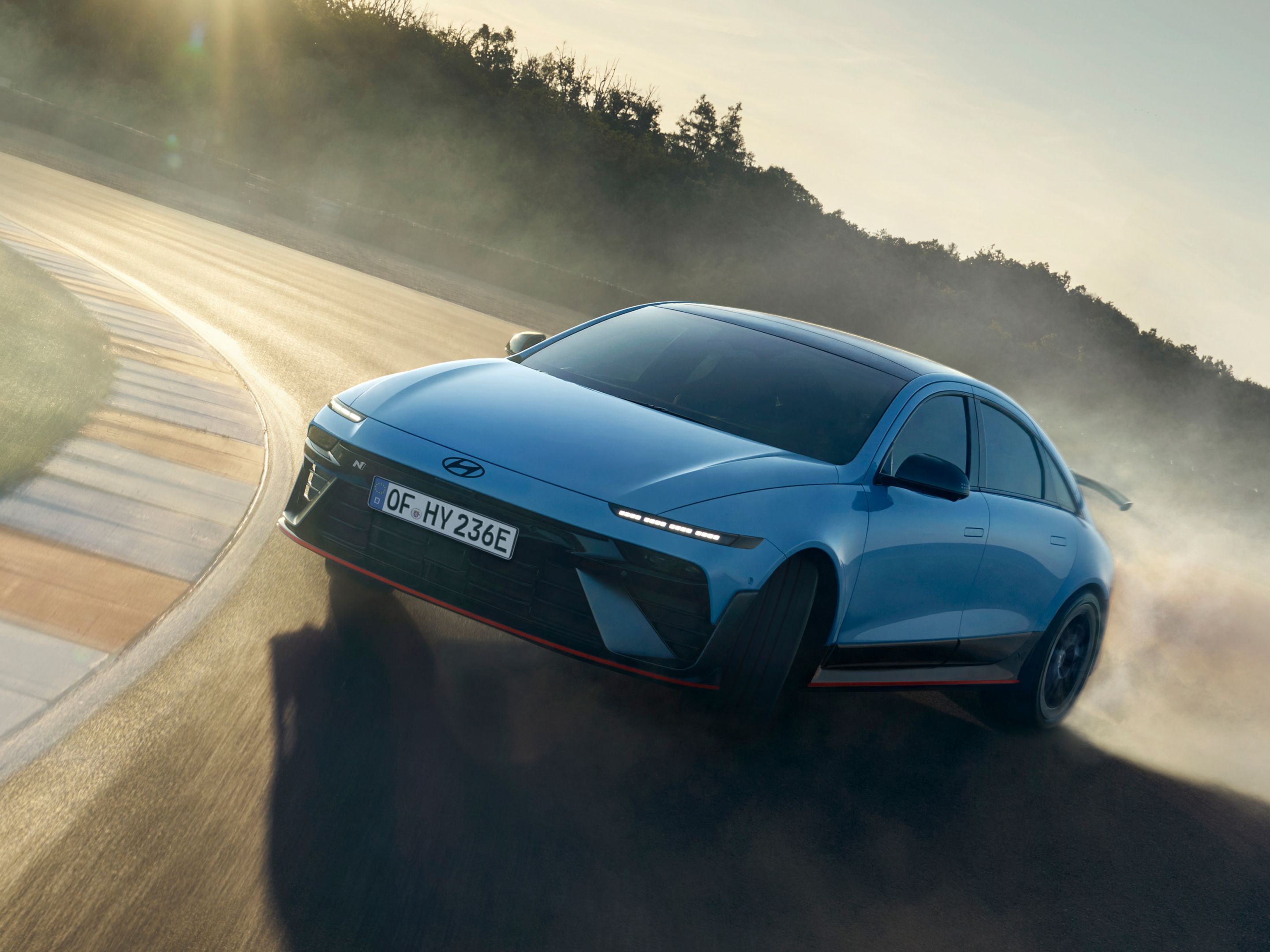 Hyundai IONIQ 6 N versenypályán driftel, por száll fel a száguldó autó mögött.