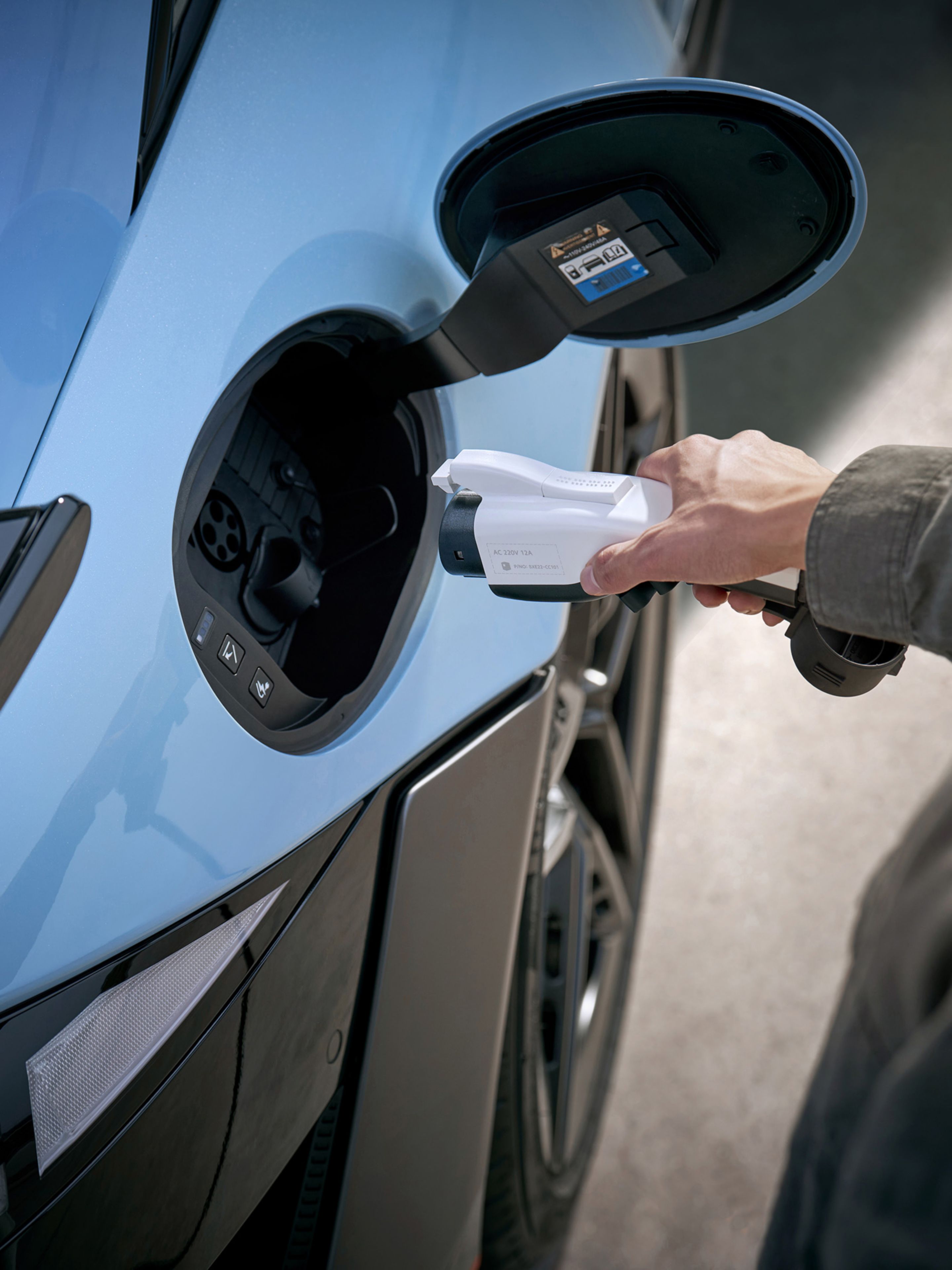 Egy személy töltőkábelt illeszt a Hyundai IONIQ 6 N töltőaljzatába. Közeli fénykép.
