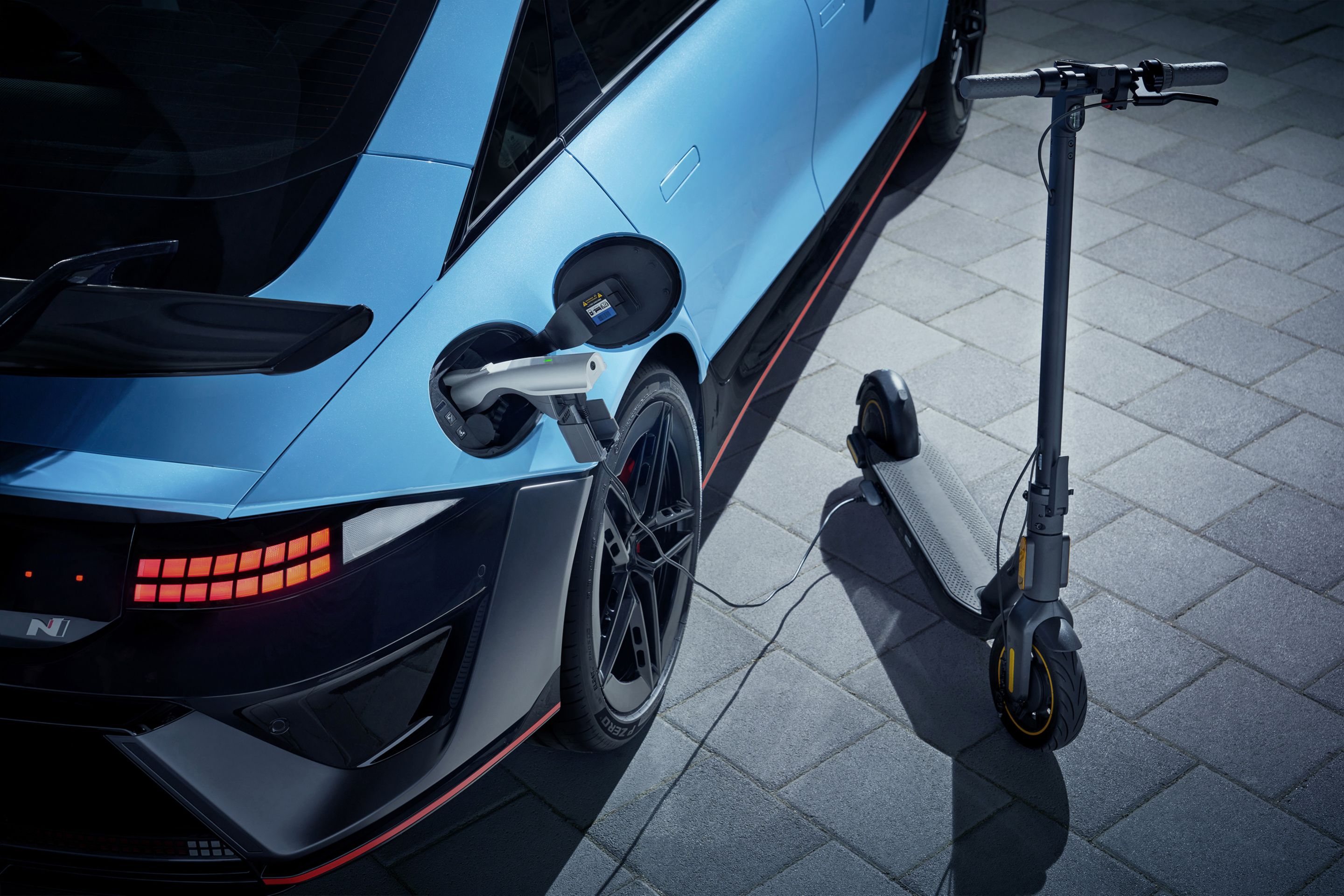 IONIQ 6 N kábelen keresztül tölt egy elektromos rollert.