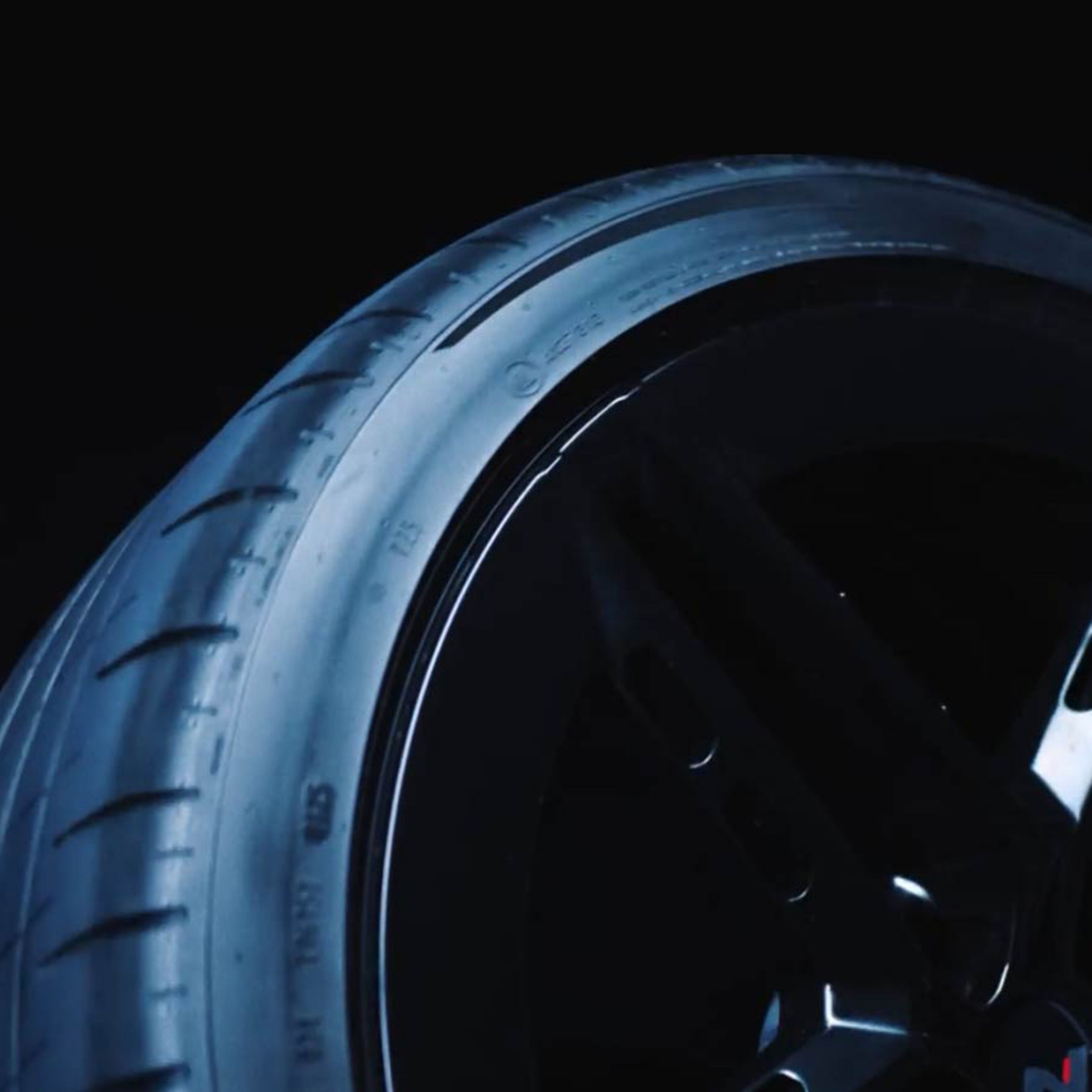 Hyundai IONIQ 6 N abroncsa közeli képen, kihangsúlyozva annak kialakítását és futófelületei mintázatát. Sötét háttér előtt.